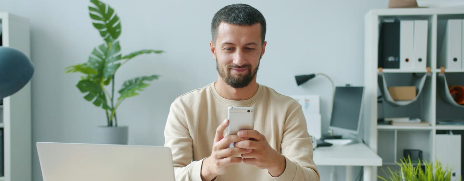 Man in an office on phone using VoIP call features