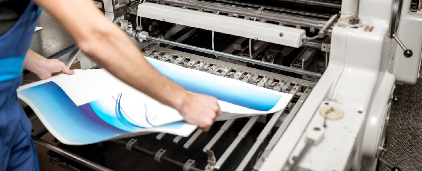 A man printing architectural plans on a wide-format printer